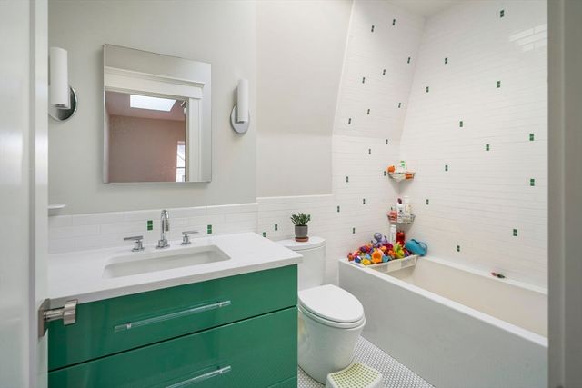 a bathroom with a tub sink toilet and a mirror