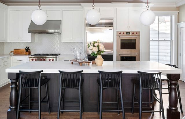 a kitchen with stainless steel appliances a table chairs and a stove