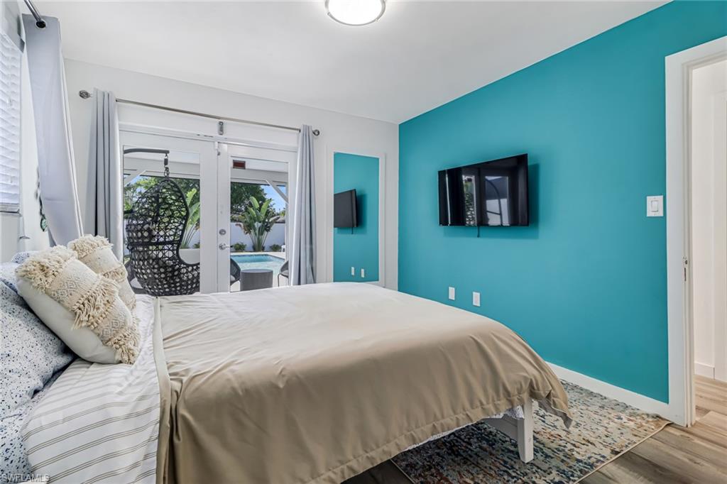 724 100th Avenue North Naples, FL 34108 - Photo 17 of 31 a bedroom with a bed and wooden floor