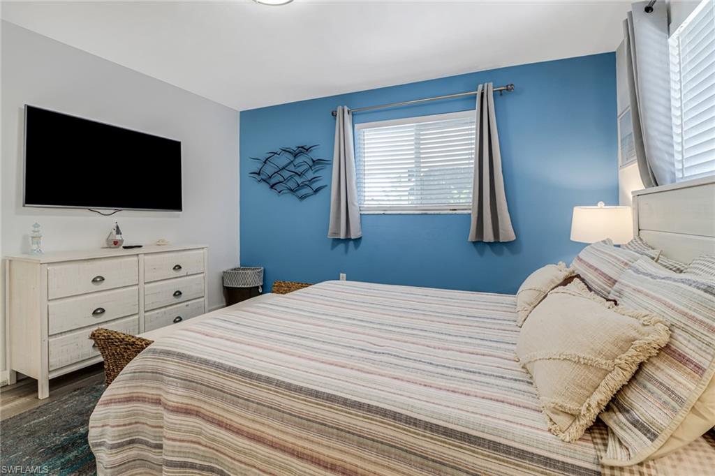 724 100th Avenue North Naples, FL 34108 - Photo 19 of 31 a bedroom with a large bed and a flat screen tv