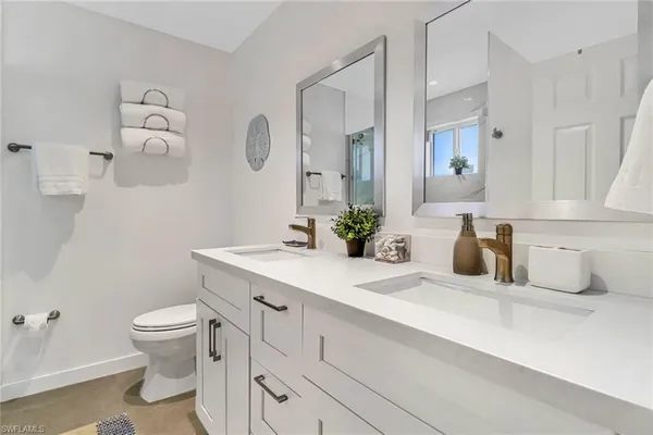 a bathroom with a sink a toilet and a mirror