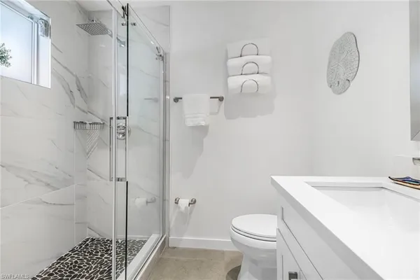 a bathroom with a sink a toilet and shower