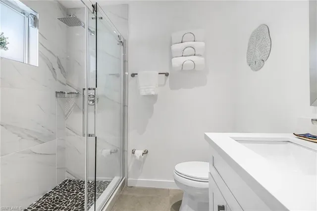 a bathroom with a sink a toilet and shower