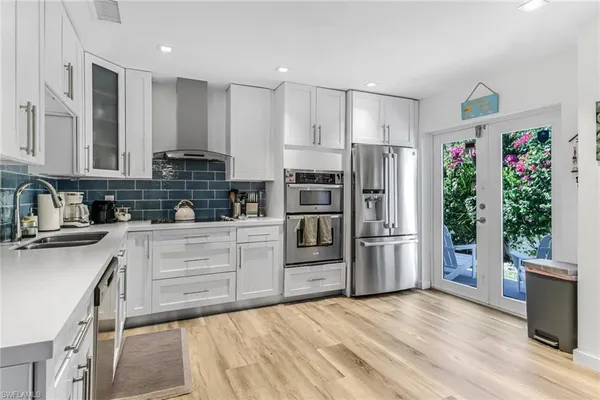 a kitchen with stainless steel appliances a refrigerator sink and microwave