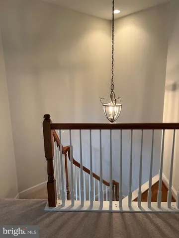 a view of staircase with railing and a chandelier