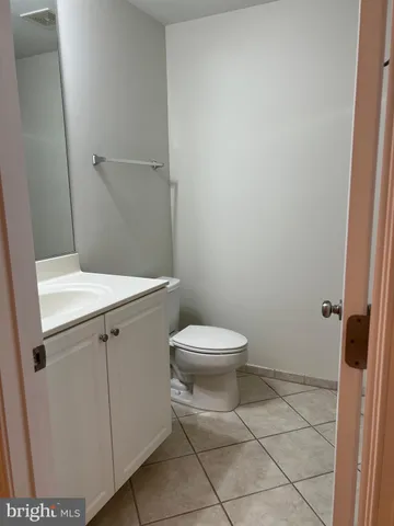 a white toilet sitting next to a white sink and vanity