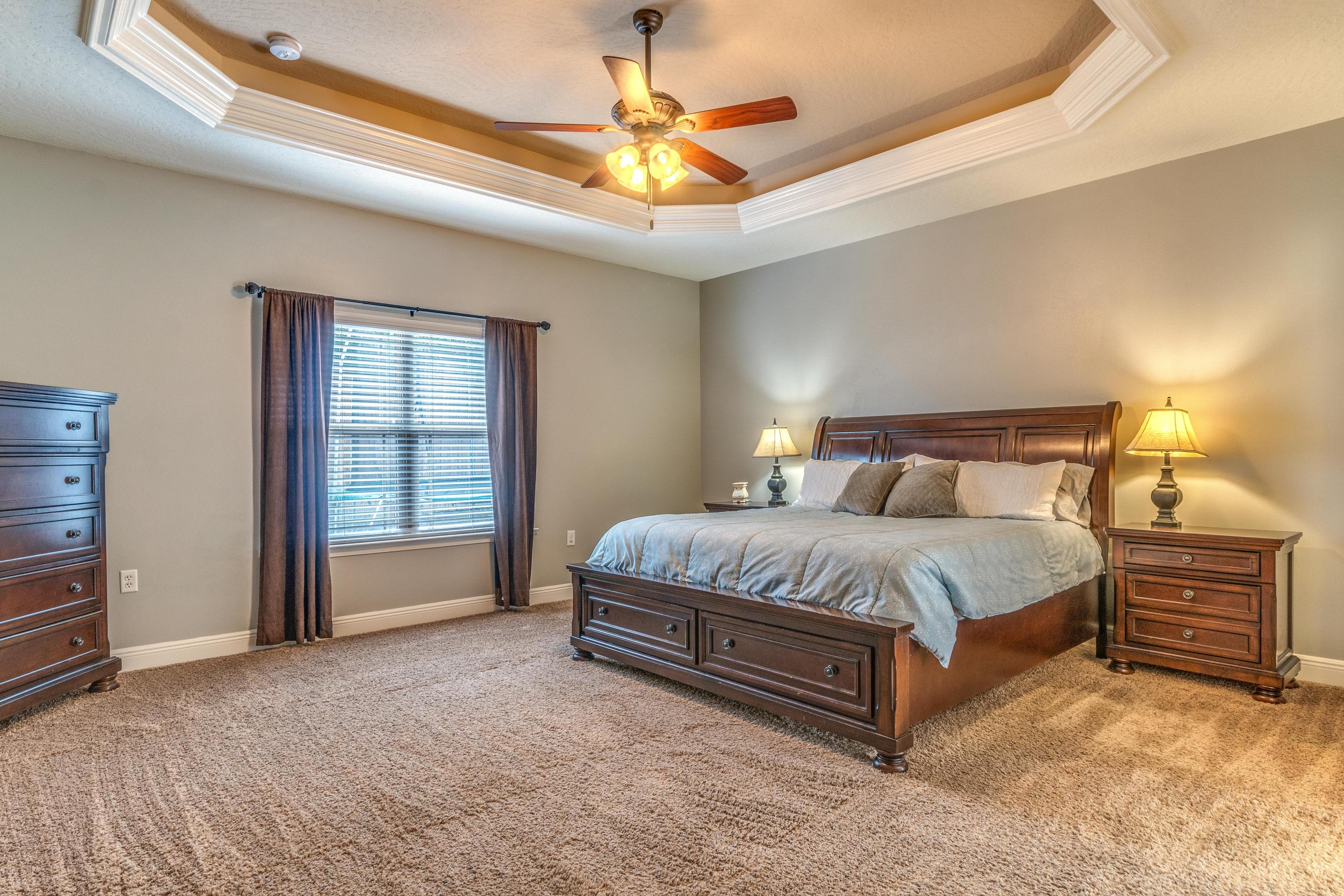 4624 Hermosa Road Crestview, FL 32539 - Photo 13 of 32 a spacious bedroom with a bed and a chandelier