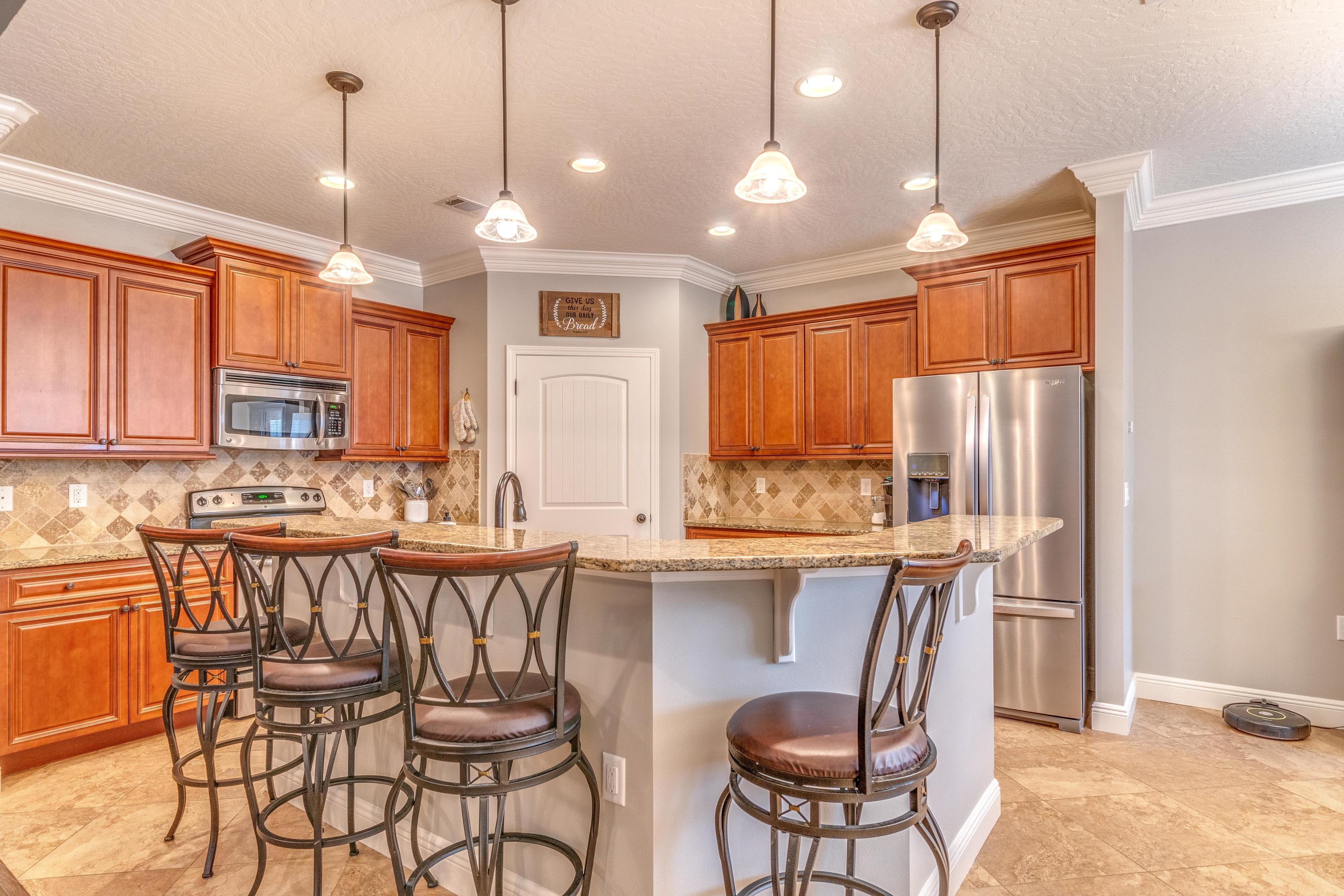 4624 Hermosa Road Crestview, FL 32539 - Photo 8 of 32 a kitchen with stainless steel appliances granite countertop a stove a refrigerator a sink dishwasher a dining table and chairs with wooden floor