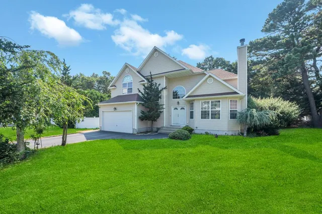 a view of a house with a big yard and large trees