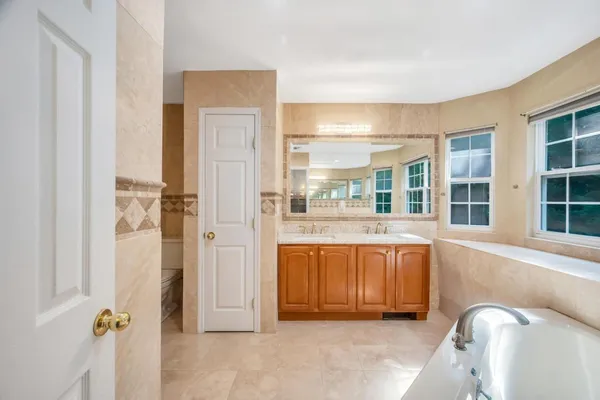 a bathroom with a tub sink and mirror