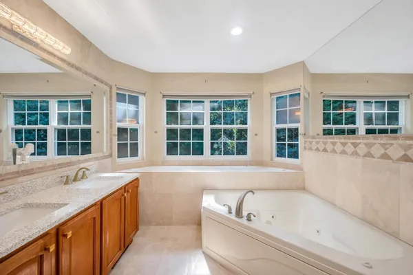 a bathroom with a tub a sink and a large window