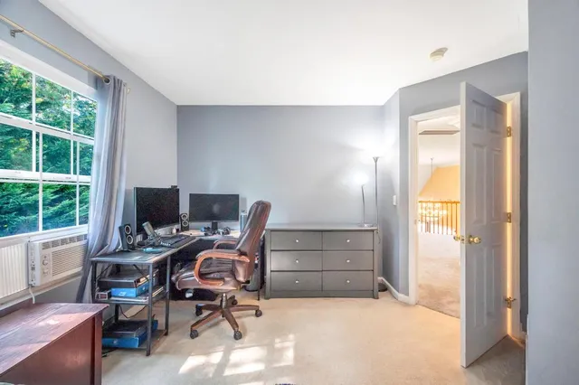 a view of a workspace with furniture and a window