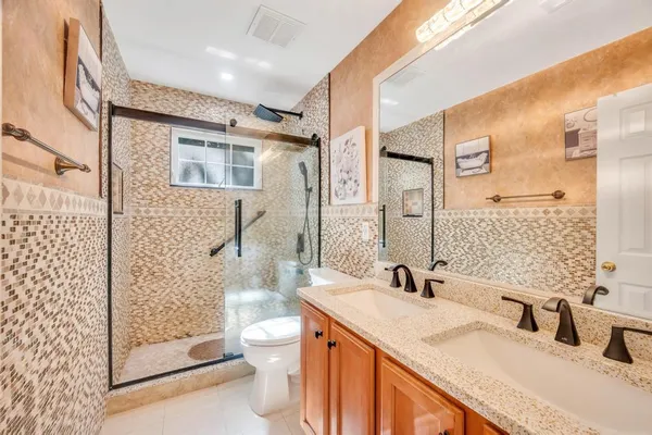 a bathroom with a granite countertop sink toilet and shower