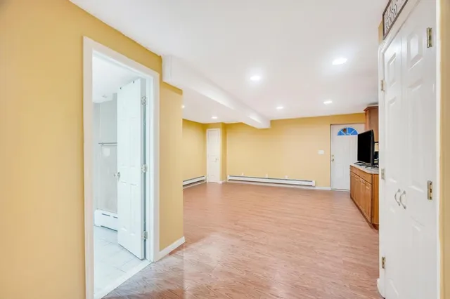 a view of a big room with wooden floor and windows