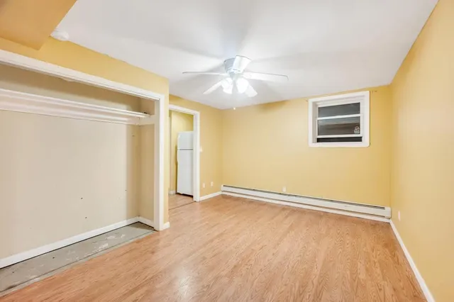 an empty room with a window and a ceiling fan