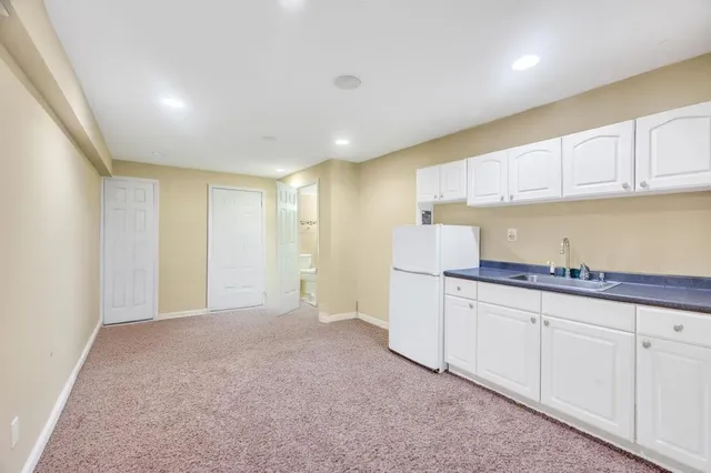 a kitchen with granite countertop white cabinets and stainless steel appliances