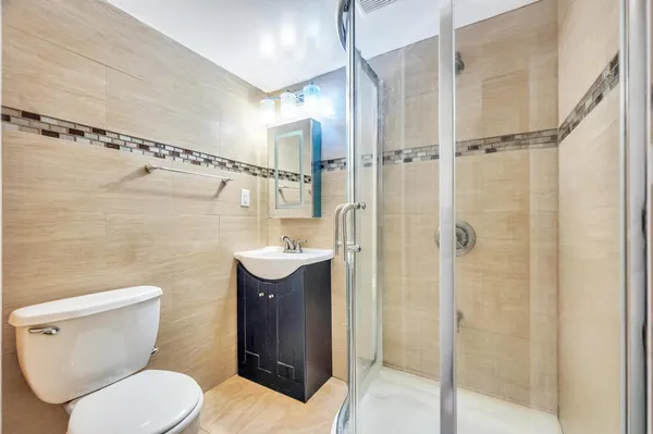 a bathroom with a toilet shower vanity and a sink