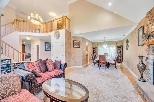 a living room with furniture a chandelier and a dining table