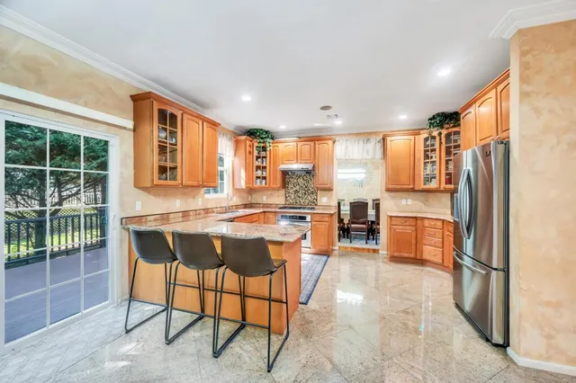 a kitchen with stainless steel appliances granite countertop a stove a sink a refrigerator and island