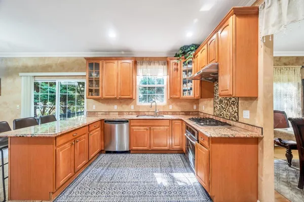 a kitchen with stainless steel appliances granite countertop a sink stove and cabinets