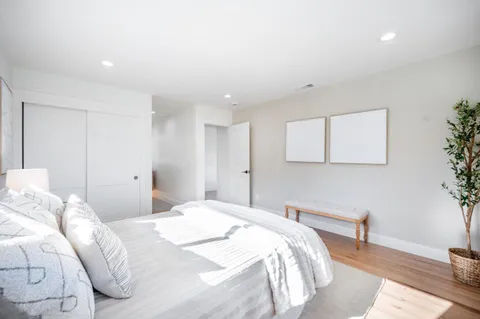 a bedroom with a bed and wooden floor