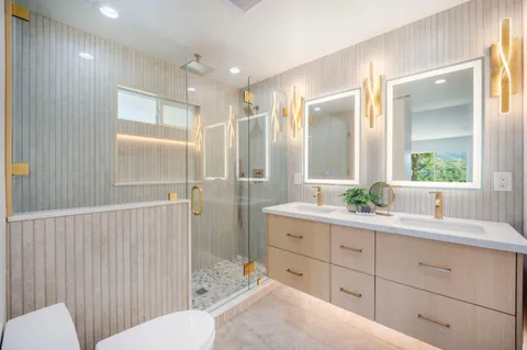 a bathroom with a double vanity sink a toilet and a mirror