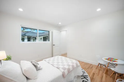 a bedroom with a large bed and a potted plant