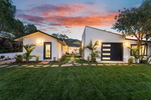a view of a street with houses a tree
