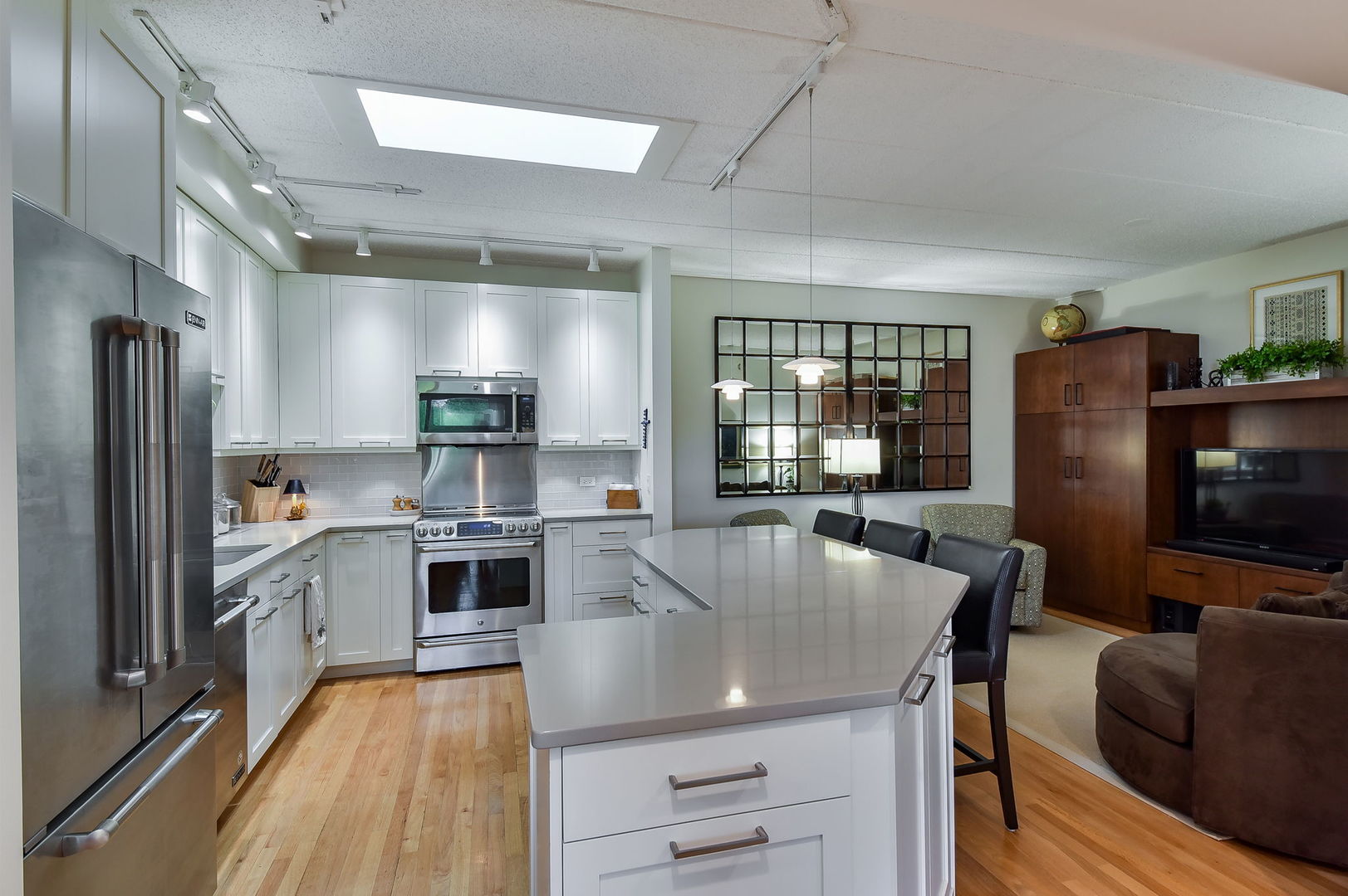 111 North Wheaton Avenue, Unit 407 Wheaton, IL 60187 - Photo 4 of 12 a large kitchen with stainless steel appliances a stove a refrigerator and a kitchen island