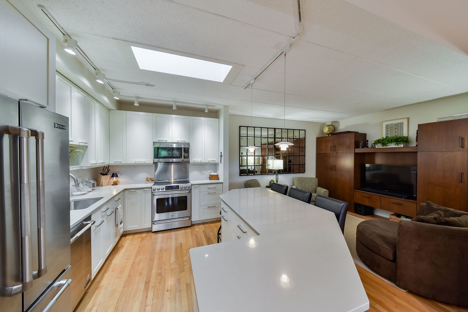 111 North Wheaton Avenue, Unit 407 Wheaton, IL 60187 - Photo 5 of 12 a large kitchen with stainless steel appliances kitchen island granite countertop a refrigerator and a stove top oven