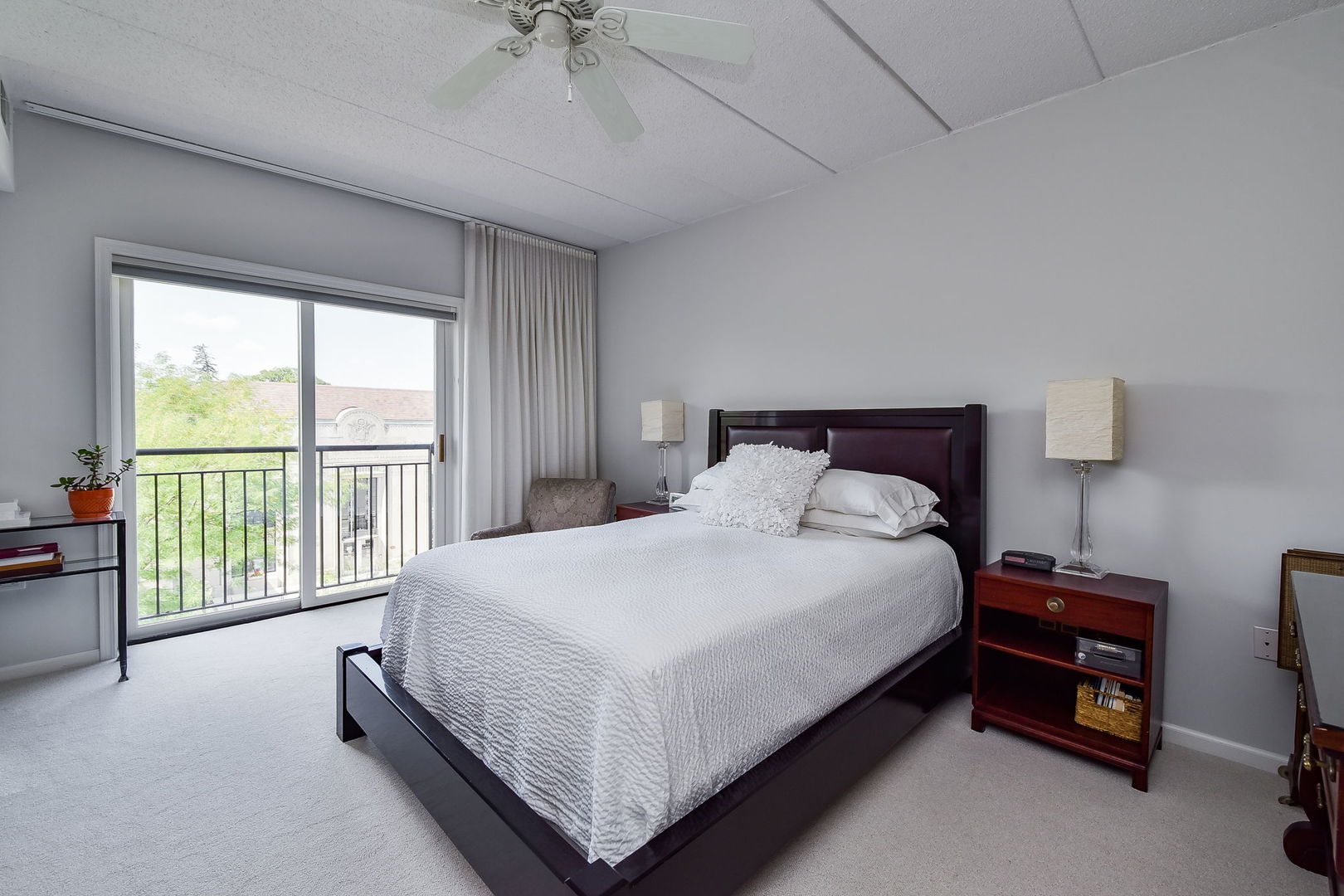 111 North Wheaton Avenue, Unit 407 Wheaton, IL 60187 - Photo 8 of 12 a large bed sitting in a bedroom next to a window