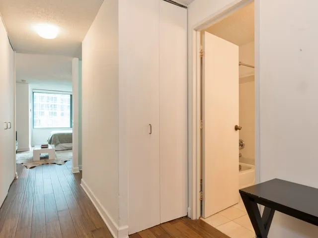 a view of a room with wooden floor windows and a bedroom
