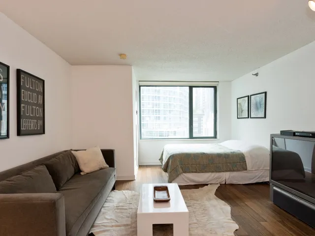 a bedroom with a bed couch and window