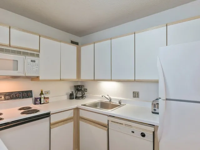 a kitchen with white cabinets and white appliances