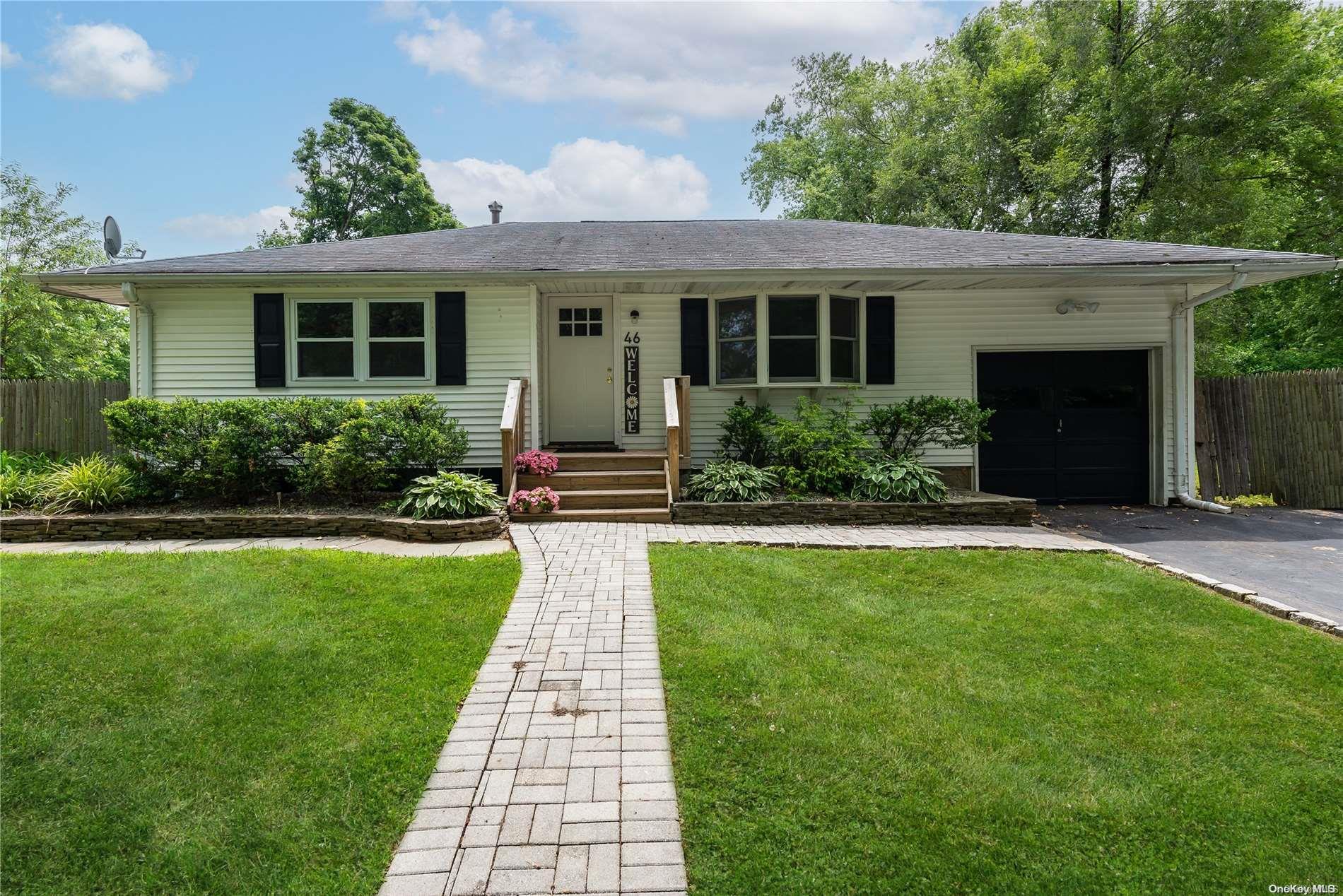 a front view of a house with yard and green space