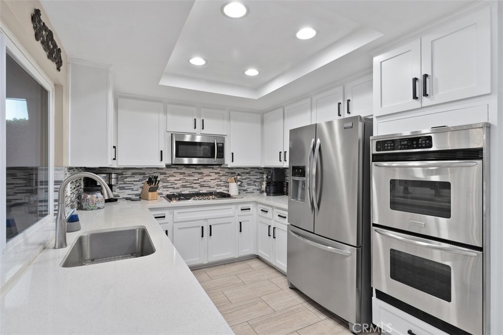 21526 Vía Serpiente Lake Forest, CA 92630 - Photo 10 of 51 a kitchen with granite countertop white cabinets and stainless steel appliances