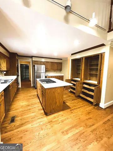 a large kitchen with stainless steel appliances kitchen island granite countertop a sink and cabinets