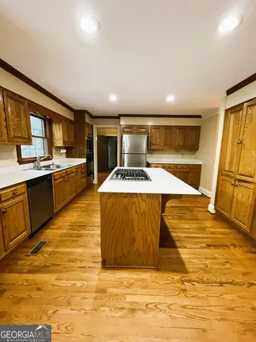 a living room with stainless steel appliances kitchen island granite countertop a stove and a refrigerator