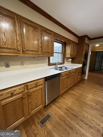 a kitchen with stainless steel appliances granite countertop a sink counter space cabinets and a large window
