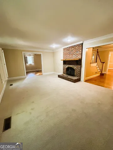 a view of a livingroom with a fireplace and window