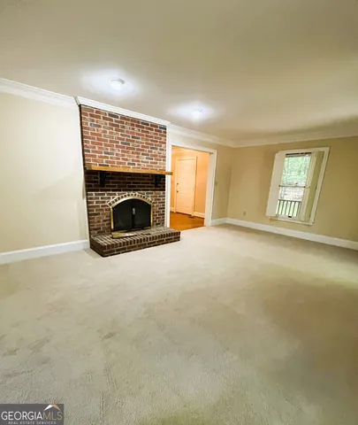 an empty room with a fireplace and windows