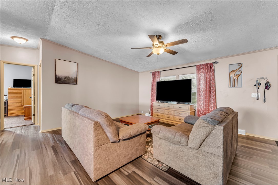 27202 Cook Road, Unit 90 Olmsted Falls, OH 44138 - Photo 3 of 36 Living room featuring wood finished floors, a textured ceiling, ornamental molding, and ceiling fan