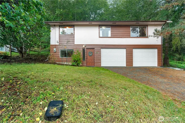 a front view of house with yard and garage
