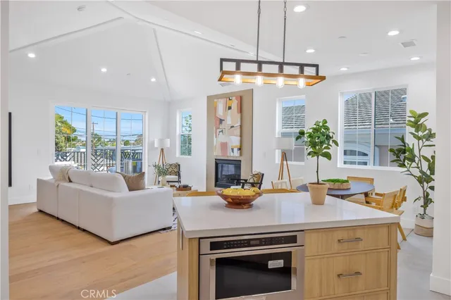 a kitchen with a refrigerator a stove and living room view