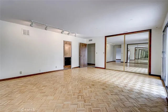 an empty room with windows and closet