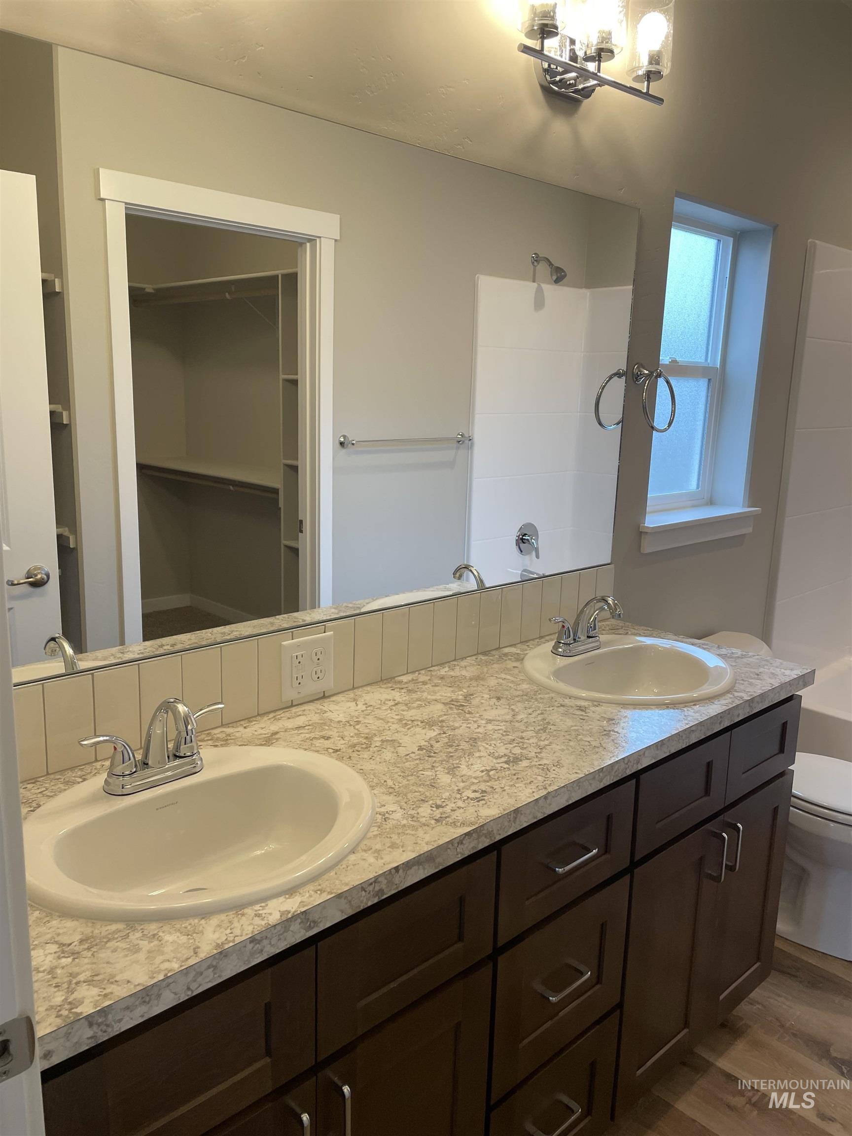 1123 Frank Henry Road Twin Falls, ID 83301 - Photo 10 of 20 Bathroom featuring double vanity, dark wood-type flooring, and a walk in closet