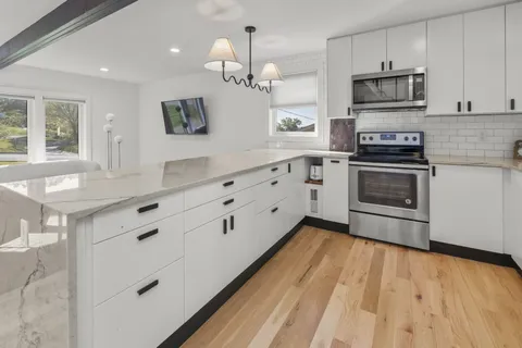 a kitchen with stainless steel appliances a stove sink and cabinets