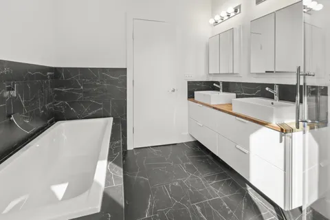 a bathroom with a tub sink and mirror