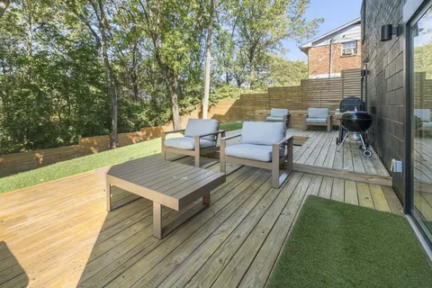 a view of a patio with couches and table on wooden floor