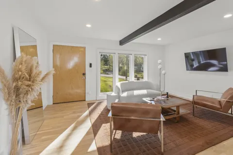 a living room with furniture and a floor to ceiling window